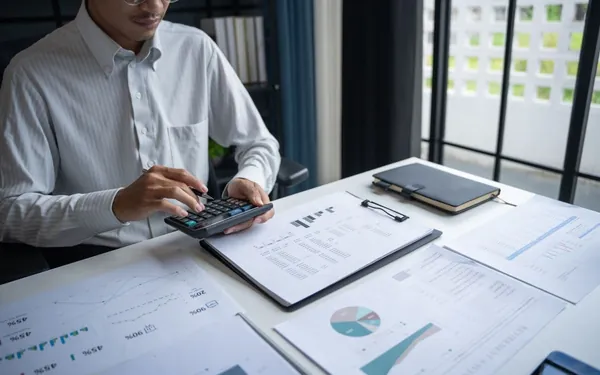 Analista con calculadora y gráficos evaluando deuda privada